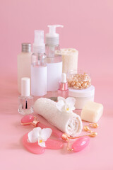 Fototapeta na wymiar Natural cosmetic jars and skin care accesories with white orchid flower on pink close up, copy space
