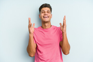 Young caucasian man isolated on blue background joyful laughing a lot. Happiness concept.