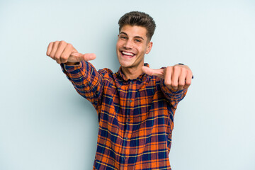 Young caucasian man isolated on blue background raising both thumbs up, smiling and confident.