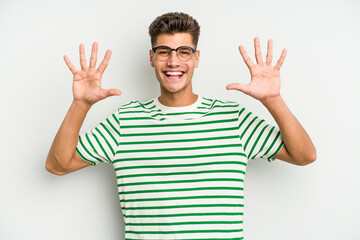Young caucasian man isolated on white background showing number ten with hands.