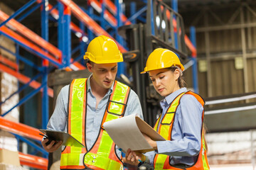Manager and supervisor taking inventory in warehouse, Female foreperson making plans with warehousemen, Workers working in warehouse