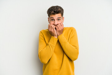 Young caucasian man isolated on white background biting fingernails, nervous and very anxious.