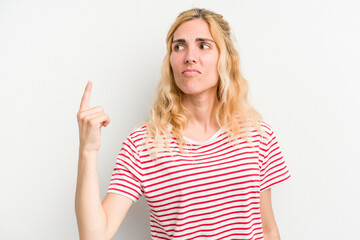 Fototapeta premium Young caucasian woman isolated on white background pointing with finger at you as if inviting come closer.