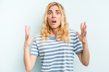 Fototapeta na wymiar Young caucasian woman isolated on blue background screaming to the sky, looking up, frustrated.