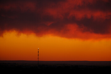 Cell Tower for Digital Communication at Sunset Silhouette