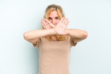 Young caucasian woman isolated on blue background doing a denial gesture