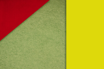 Textured and plain neon red yellow green sheet papers forming two triangles and vertical blank rectangle for creative cover designing