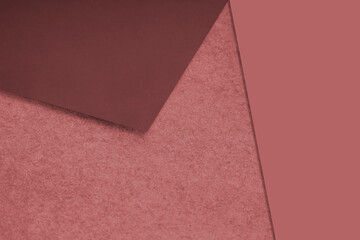 Plain and Textured pastel red maroon papers randomly laying to form M like pattern and triangle for creative cover design idea