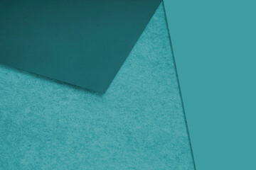 Plain and Textured pastel blue green papers randomly laying to form M like pattern and triangle for creative cover design idea