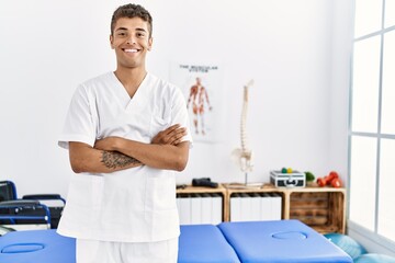 Obraz premium Young hispanic man working as physiotherapist at physiotherapy room