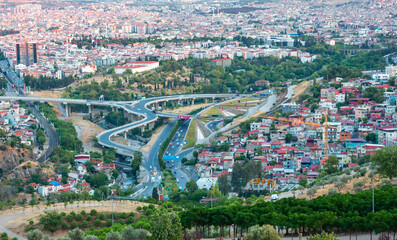 Landscape of city with highways crossing over in round shapes at sunset.