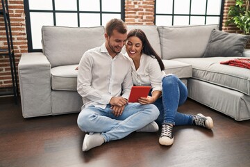 Man and woman couple smiling confident using touchpad at home