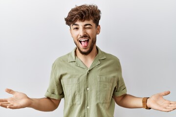 Young arab doctor man standing over isolated background sticking tongue out happy with funny expression. emotion concept.