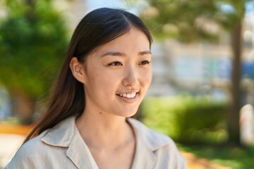 Chinese woman smiling confident looking to the side at park