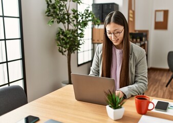 Young chinese businesswoman using laptop working at the office.