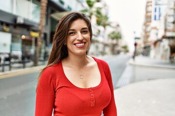 Young hispanic girl smiling happy standing at the city.