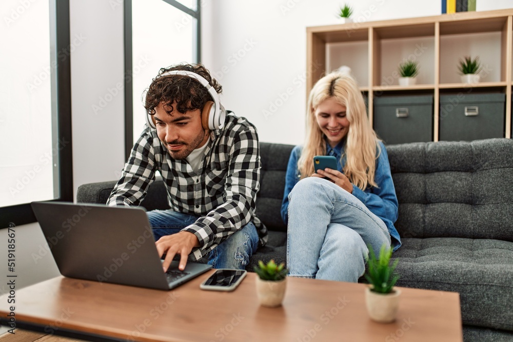 Poster young couple smling happy using laptop and smartphone at home.