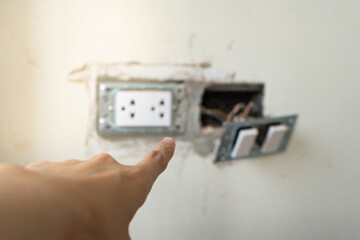 Close up inspector or audit hand point at plug socket outlet while fixing on residential electric...