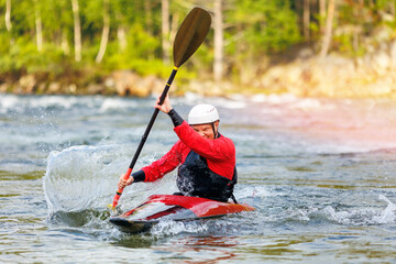 Extreme water sports, rafting on mountain river in kayak. Kayaker man strives for victory, boating...