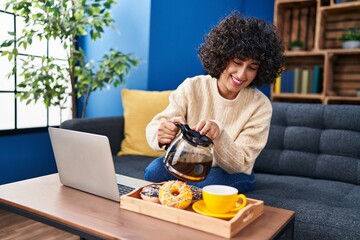 Fototapeta na wymiar Young middle east woman using laptop having breakfast at home
