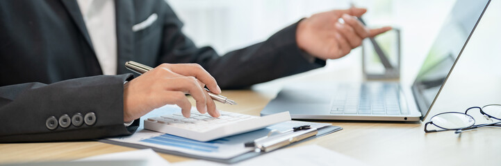 Close up of businessperson using laptop working with digital data..