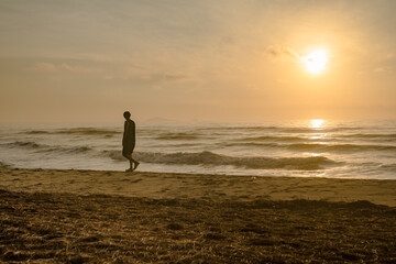 Fototapeta na wymiar silhouette man run on beach with sunrise and sea background