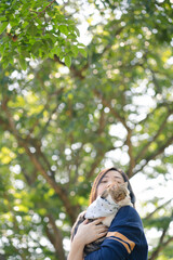 asian woman feel happy during relax and play with her cat at park