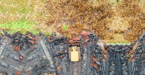 Panoramic aerial view of heavy yellow bulldozer leveling ground at construction site.