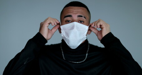 Hispanic latino young man adjusting face mask