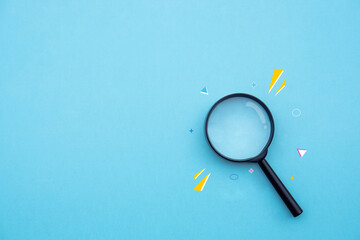 Magnifying glass on blue background in pastel colours.