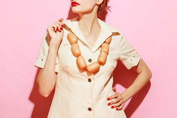 Cropped image of woman having necklace made from sausages. Creative food advertisement