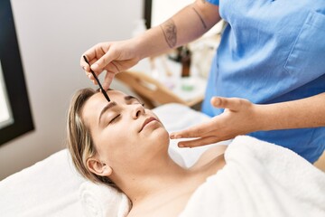 Obraz na płótnie Canvas Woman couple having eyebrows treatment at beauty center