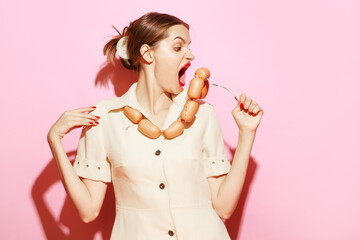 Young woman emotionally eating sausage on her necklace Creative food advertisement. Food addiction