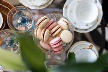 A dessert table setting with macaroons, coffee cups and champagne glasses all in a light atmosphere...