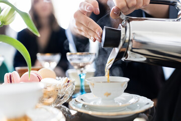 Coffee being poured from a thermos into a gorgeous white porcelain coffee cup