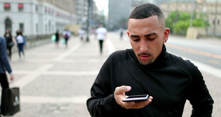 Hispanic casual person using smartphone in downtown city