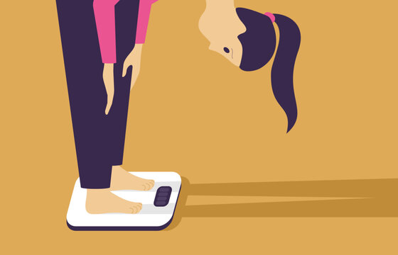 Woman stands on body scales - weight loss