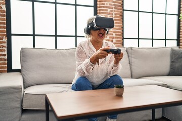 Middle age woman playing video game at home