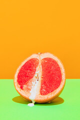 Naklejka na ściany i meble Image of juicy grapefruit isolated on green orange background