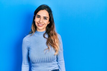 Obraz premium Young hispanic girl wearing casual clothes looking away to side with smile on face, natural expression. laughing confident.
