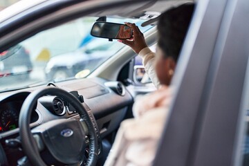 Naklejka premium African american woman smiling confident driving car at street