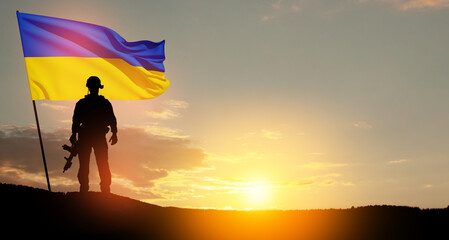 Flag of Ukraine with silhouette of soldier against the sunrise or sunset. Concept - armed forces of...