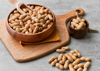 Image of wooden spoons with peanuts on a concrete surface