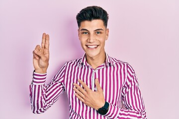 Young hispanic man wearing casual clothes smiling swearing with hand on chest and fingers up,...