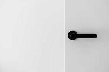 Black metal handle on white minimalist door - obrazy, fototapety, plakaty