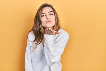 Young caucasian girl wearing casual clothes looking at the camera blowing a kiss with hand on air being lovely and sexy. love expression.