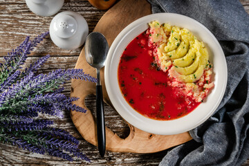 Red borscht soup in bowl.