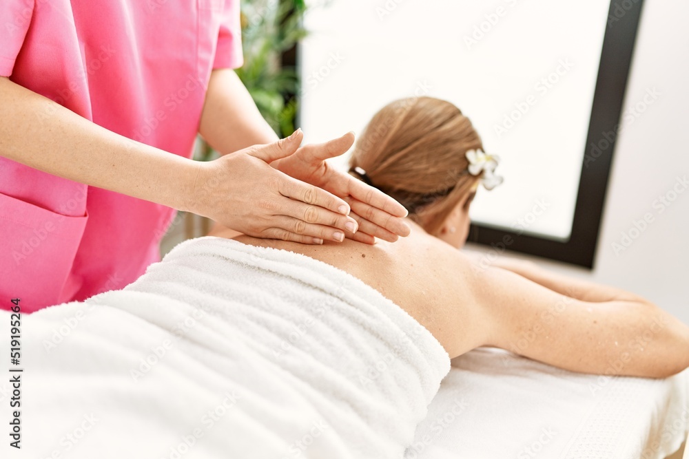 Poster middle age caucasian woman having back massage at beauty center