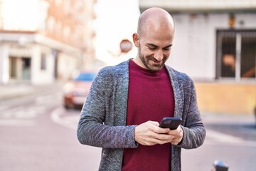 Young man smiling confident using smartphone at street