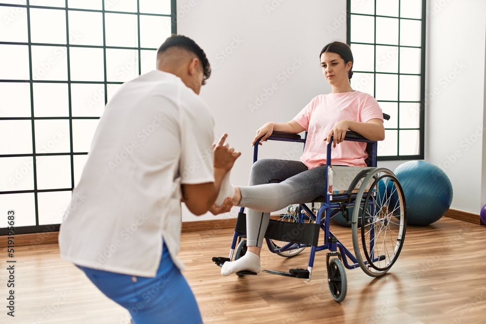 Wall mural Young disabled woman having mobility exercise sitting on wheelchair at the clinic.